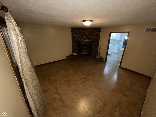 unfurnished living room with a textured ceiling and a fireplace