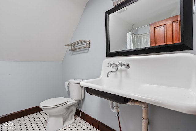 bathroom with toilet, lofted ceiling, and walk in shower