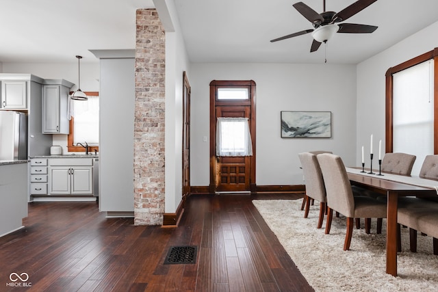 dining space with dark wood-type flooring, ceiling fan, and sink