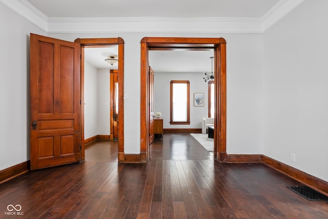 unfurnished room featuring dark wood-type flooring and crown molding