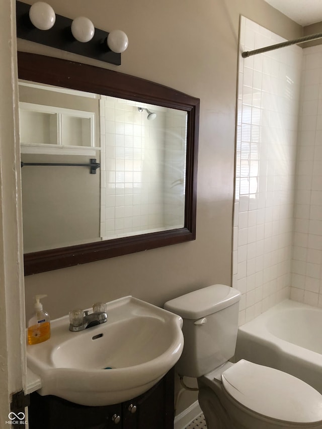 full bathroom with toilet, tiled shower / bath combo, and sink