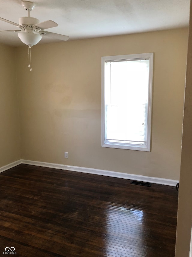 unfurnished room with dark wood-type flooring and ceiling fan