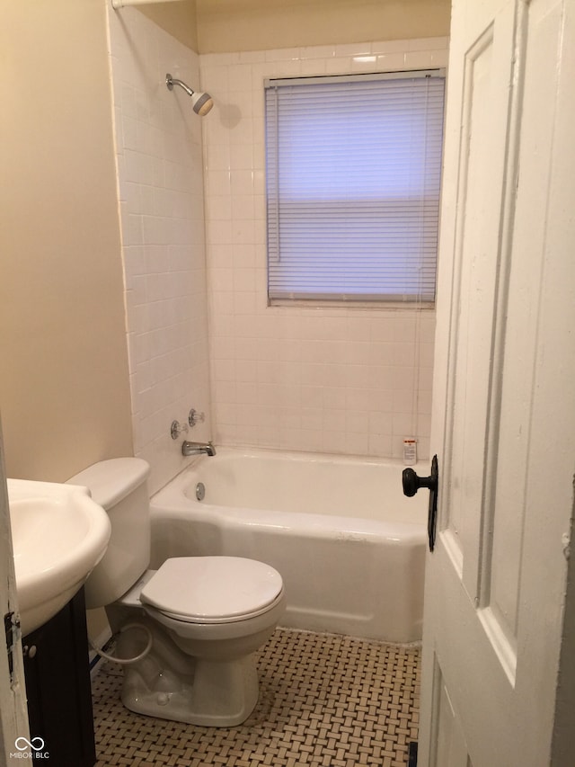 bathroom with tile patterned flooring, tiled shower / bath, and toilet