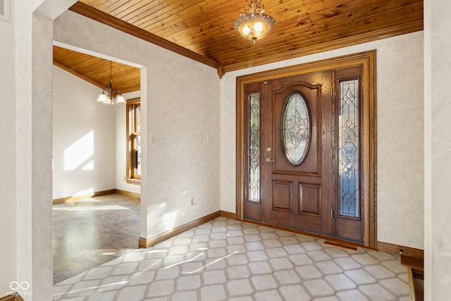 foyer with a wealth of natural light, crown molding, wood ceiling, and a notable chandelier