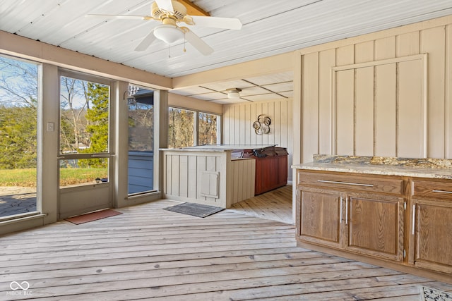 unfurnished sunroom with ceiling fan