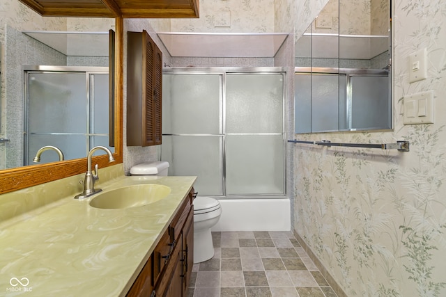 full bathroom featuring vanity, toilet, ornamental molding, and bath / shower combo with glass door