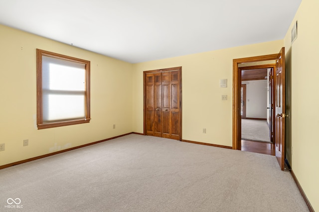 unfurnished bedroom with light carpet and a closet