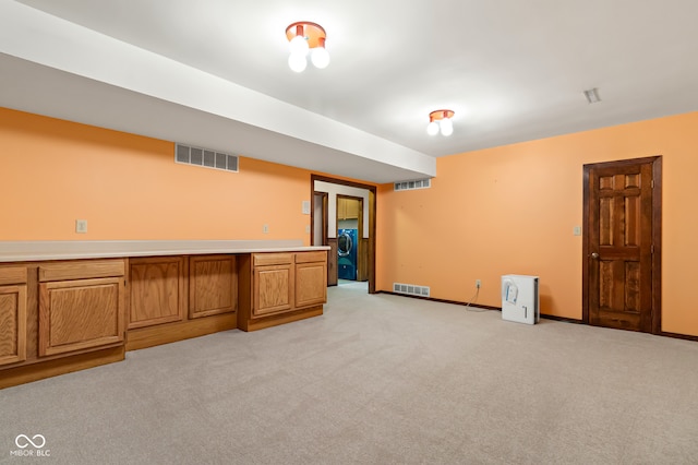 basement with light colored carpet and washer / clothes dryer