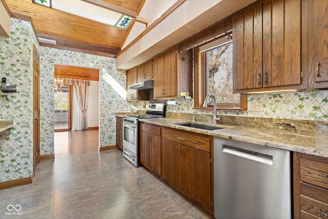 kitchen with light stone countertops, sink, stainless steel appliances, backsplash, and vaulted ceiling