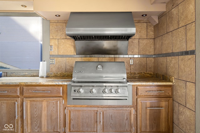 kitchen featuring backsplash and wall chimney range hood