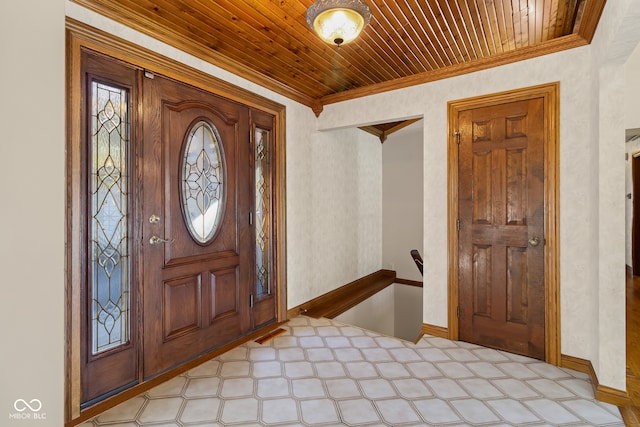 foyer entrance featuring wood ceiling and ornamental molding