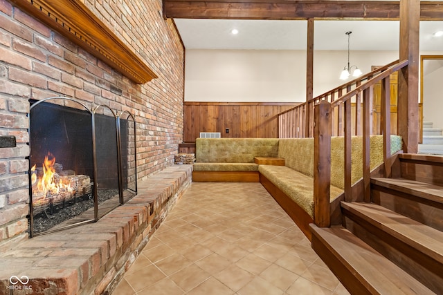 interior space featuring wood walls, a fireplace, brick wall, and a chandelier