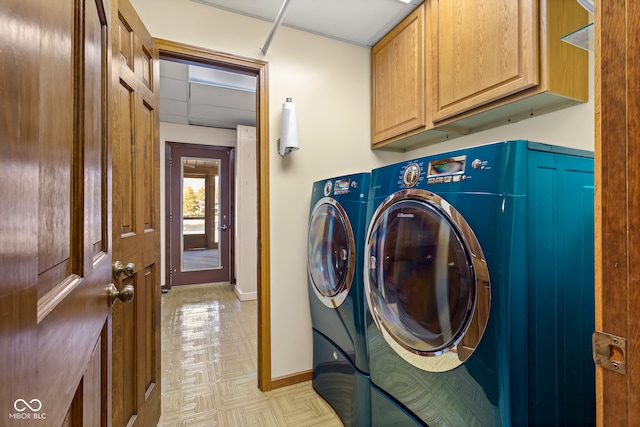 washroom featuring separate washer and dryer, light parquet flooring, and cabinets