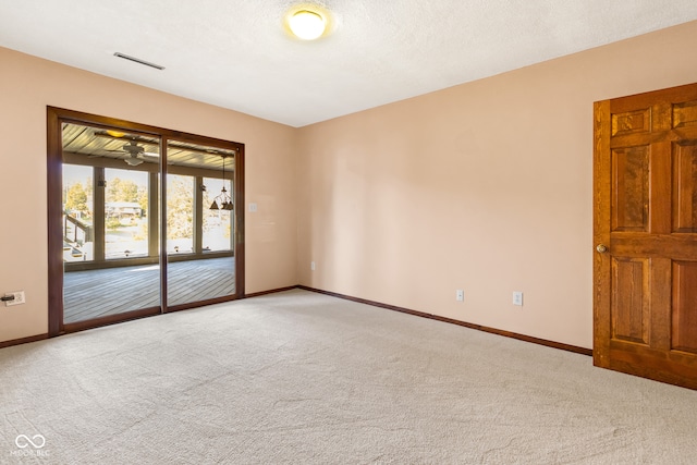 empty room with a textured ceiling, carpet floors, and ceiling fan