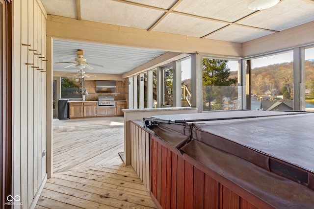 interior space featuring grilling area, ceiling fan, an outdoor kitchen, and a hot tub