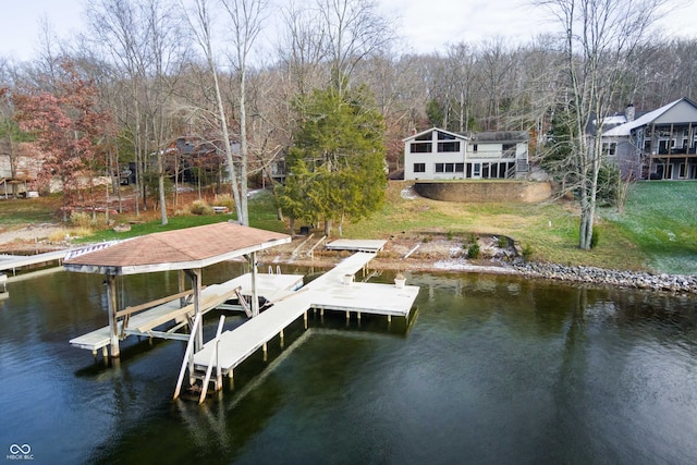 dock area with a lawn and a water view