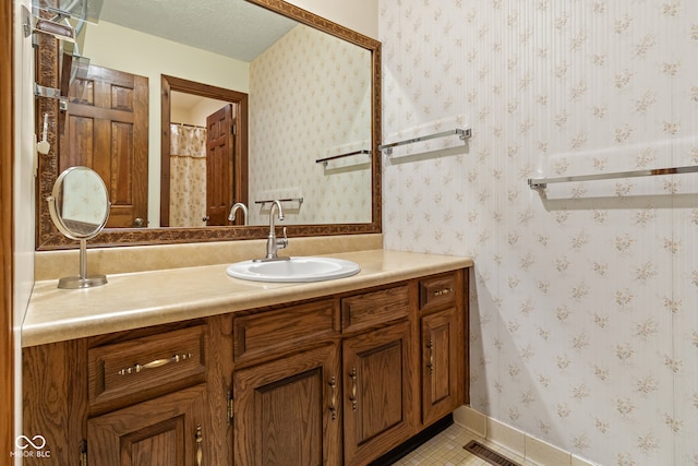 bathroom with tile patterned floors, vanity, and a textured ceiling