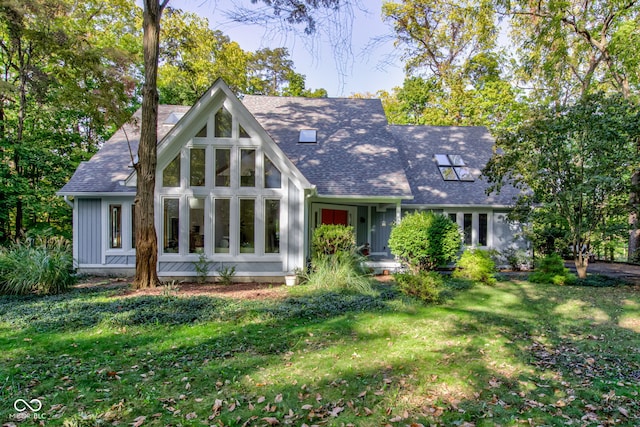 rear view of property featuring a lawn