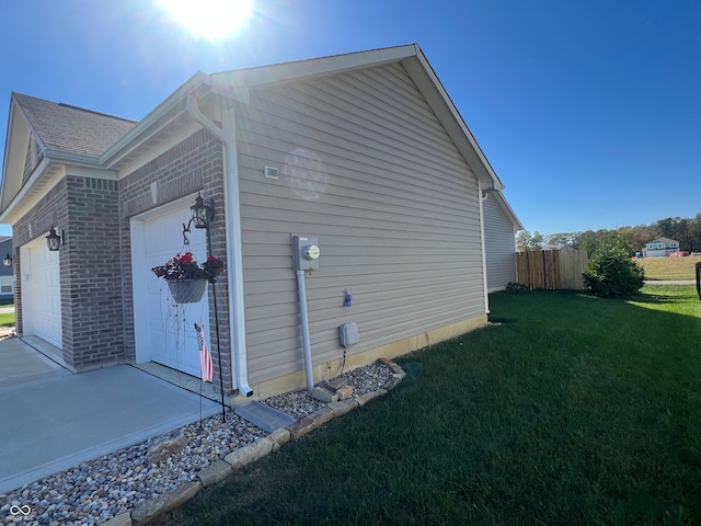 view of side of home with a garage and a yard