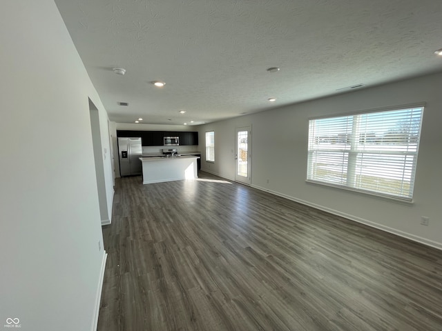 unfurnished living room featuring dark hardwood / wood-style floors and a textured ceiling