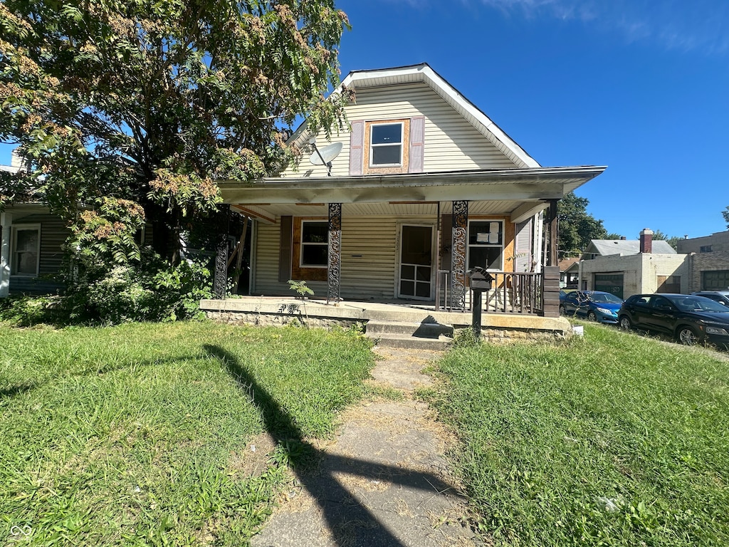 view of front of house with a porch and a front yard