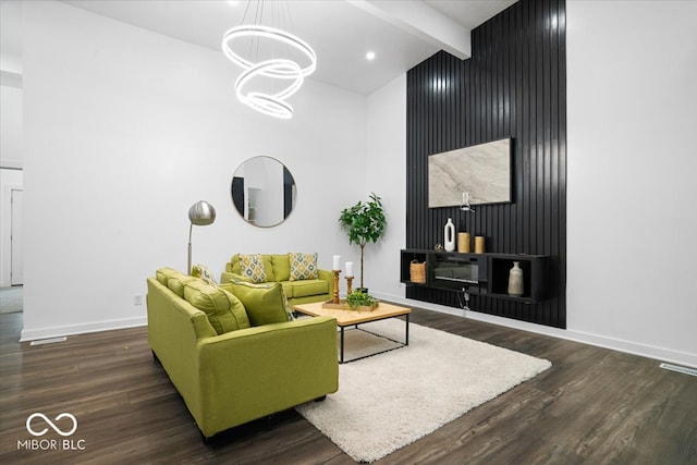 living room featuring vaulted ceiling with beams, wooden walls, a notable chandelier, and dark hardwood / wood-style floors