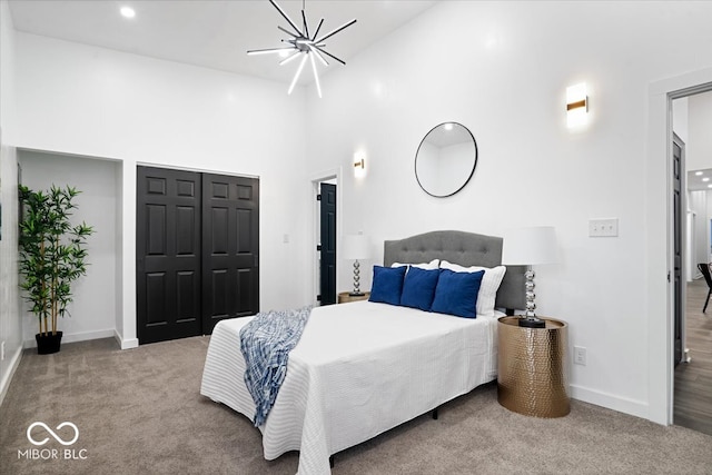 carpeted bedroom with a notable chandelier and high vaulted ceiling