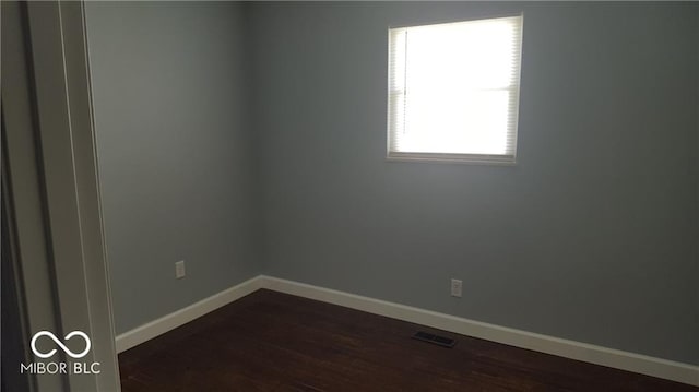 spare room with dark hardwood / wood-style flooring