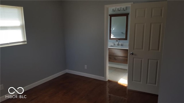 unfurnished bedroom featuring sink and dark wood-type flooring