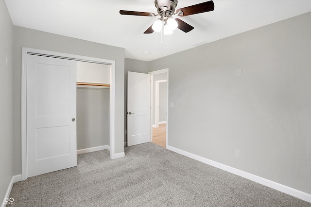 unfurnished bedroom with light colored carpet, a closet, and ceiling fan