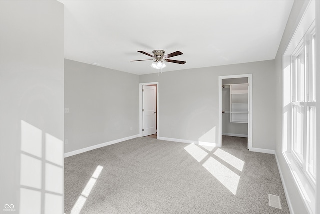 carpeted empty room featuring ceiling fan and a healthy amount of sunlight