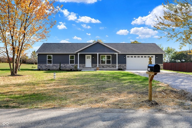 ranch-style home featuring a front yard, a garage, and covered porch