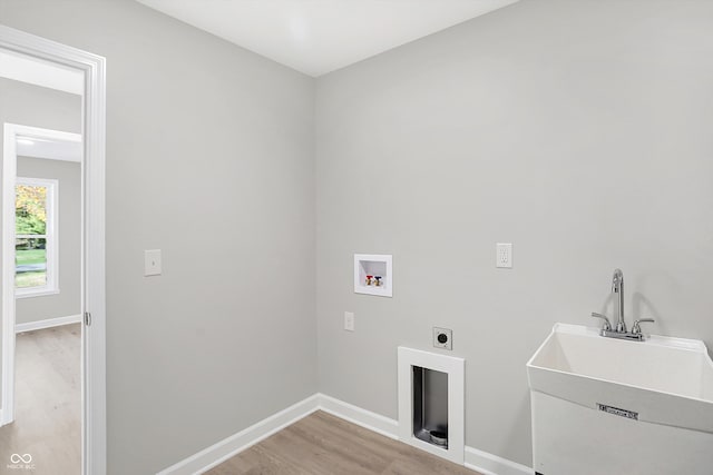 washroom featuring hookup for an electric dryer, light hardwood / wood-style floors, washer hookup, and sink