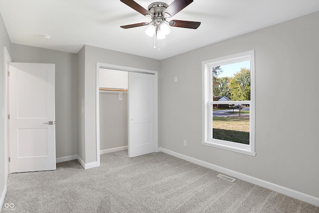 unfurnished bedroom featuring a closet, ceiling fan, and light colored carpet