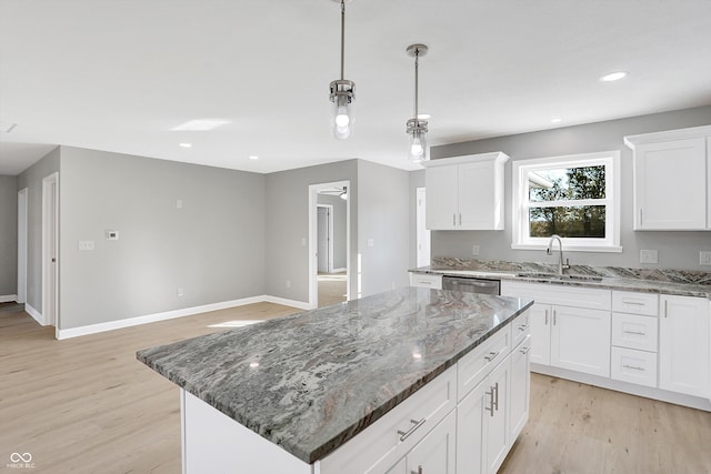 kitchen featuring sink, a center island, white cabinetry, light hardwood / wood-style floors, and dark stone countertops