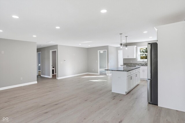7234 N Christopher Ln, Fairland, IN 46126 - kitchen with freestanding refrigerator, light wood-type flooring, a kitchen island, and baseboards