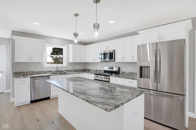 7234 N Christopher Ln, Fairland, IN 46126 - kitchen featuring light wood finished floors, light stone countertops, a center island, appliances with stainless steel finishes, and white cabinetry