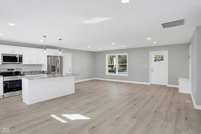 kitchen with a kitchen island, hanging light fixtures, white cabinetry, appliances with stainless steel finishes, and light hardwood / wood-style floors