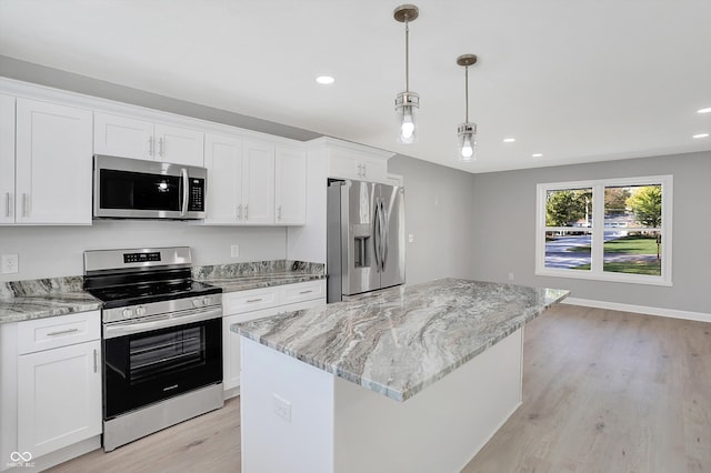 kitchen featuring a center island, white cabinets, stainless steel appliances, and light wood-type flooring