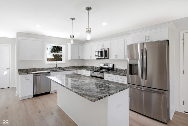 kitchen featuring white cabinetry, appliances with stainless steel finishes, light hardwood / wood-style flooring, and a kitchen island