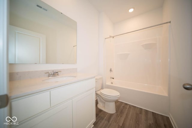 full bathroom with hardwood / wood-style flooring, vanity, toilet, and shower / tub combination