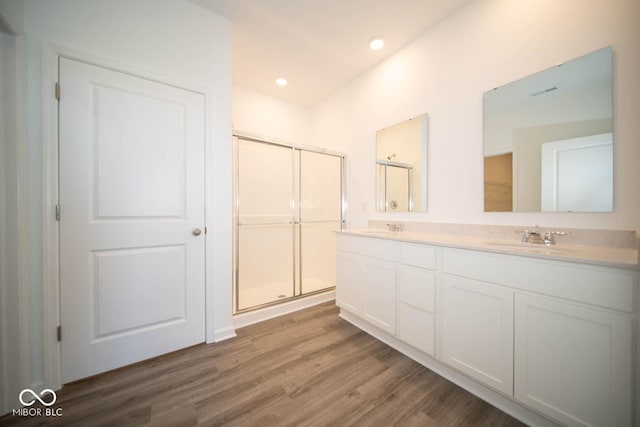 bathroom featuring vanity, an enclosed shower, and wood-type flooring