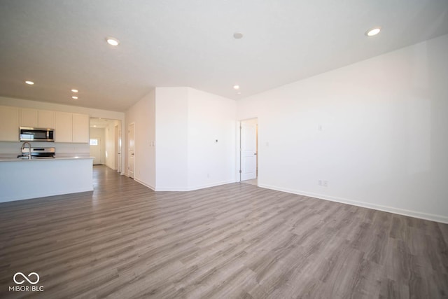 unfurnished living room with sink and light hardwood / wood-style flooring