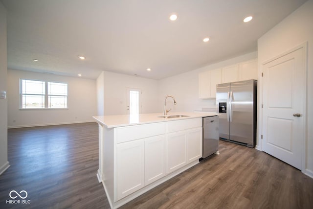 kitchen featuring dark hardwood / wood-style flooring, stainless steel appliances, sink, a center island with sink, and white cabinetry