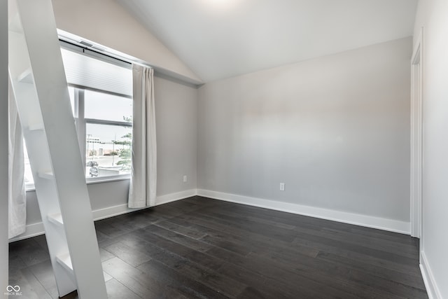 unfurnished room with lofted ceiling and dark hardwood / wood-style floors