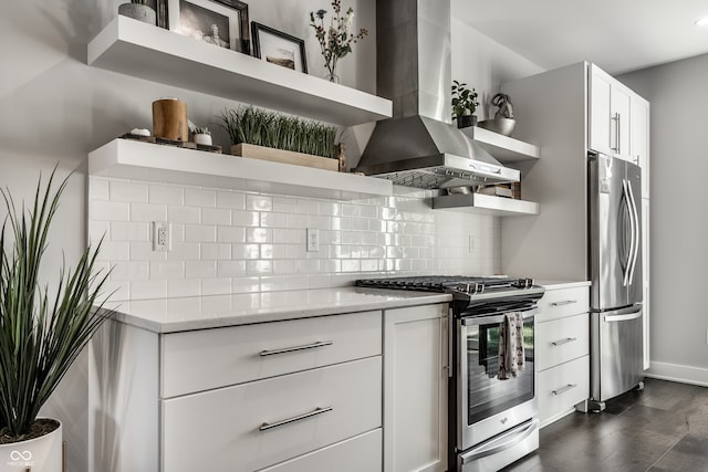 kitchen with stainless steel appliances, wall chimney range hood, white cabinets, and decorative backsplash