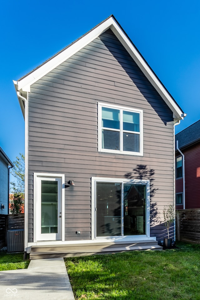 rear view of property featuring a lawn