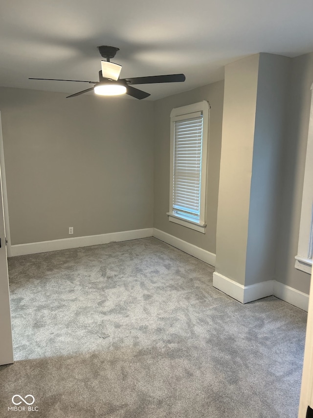 carpeted spare room with ceiling fan