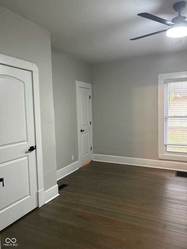 empty room featuring ceiling fan and dark hardwood / wood-style flooring