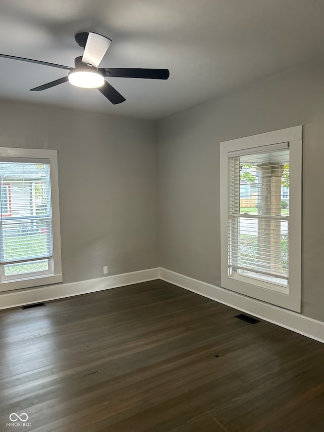 unfurnished room featuring dark hardwood / wood-style flooring, ceiling fan, and plenty of natural light